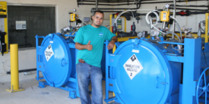 ChlorTainer maintenance person standing next to chlorine containment system.